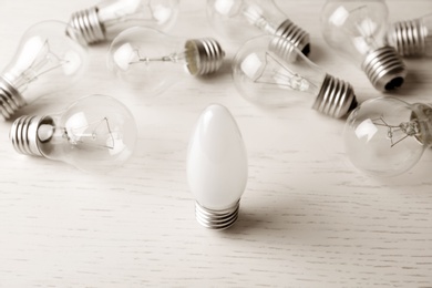 Photo of Frosted and transparent lamp bulbs on white wooden table