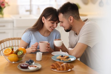 Happy couple having tasty breakfast at home