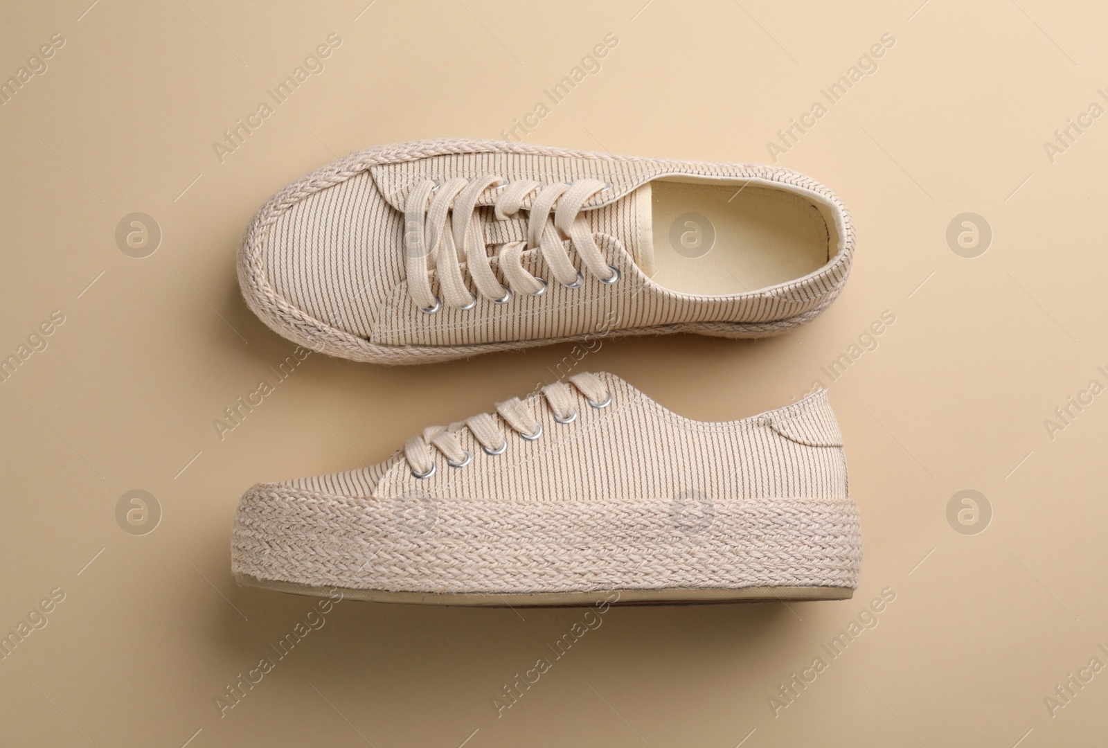 Photo of Pair of stylish comfortable shoes on beige background, flat lay