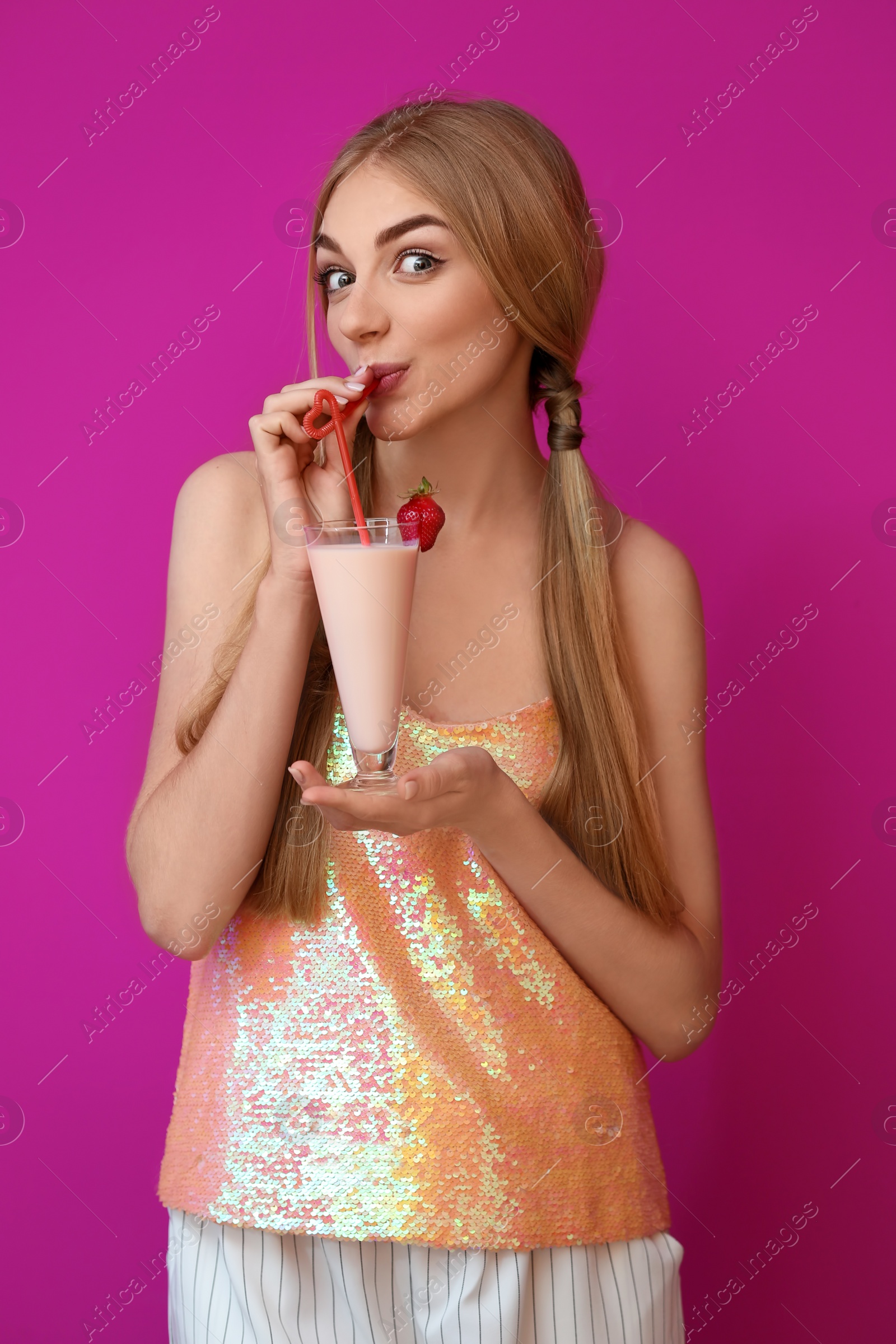 Photo of Young woman with glass of delicious milk shake on color background