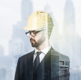 Image of Multiple exposure of architect with safety hardhat and buildings