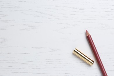 Photo of Lip pencil on white wooden table, flat lay with space for text. Cosmetic product