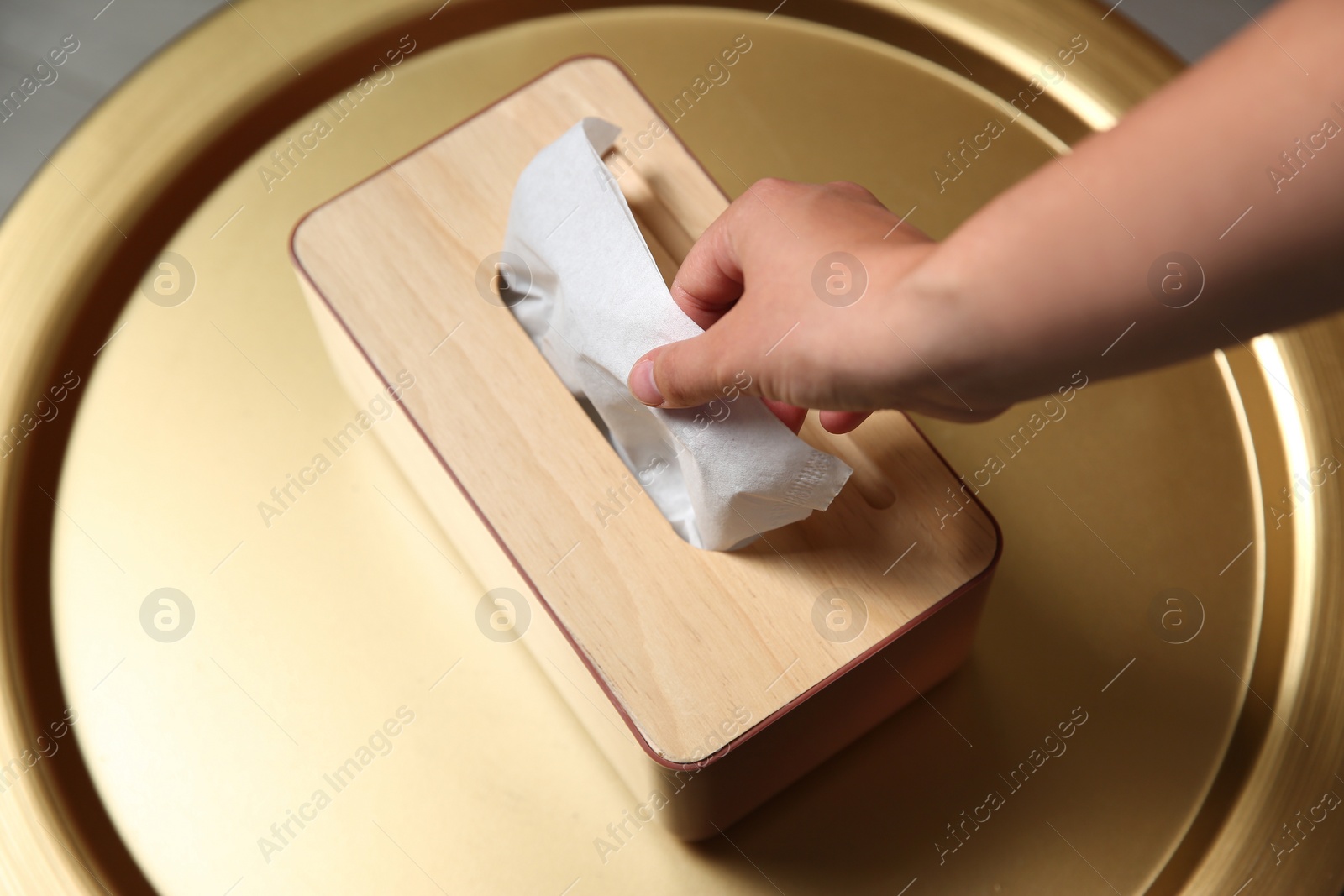 Photo of Woman taking paper tissue out of box on table, above view