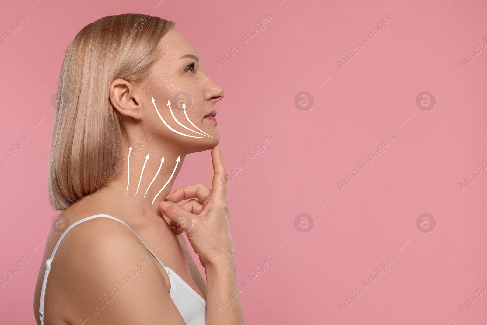 Image of Woman with perfect skin after cosmetic treatment on pink background, space for text. Lifting arrows on her neck and face