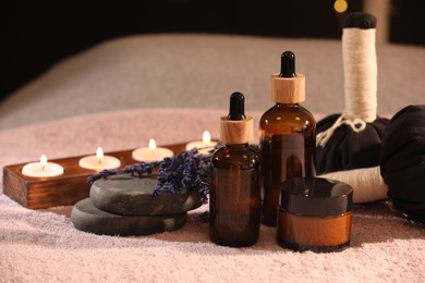 Photo of Composition with spa products and burning candles on soft light surface