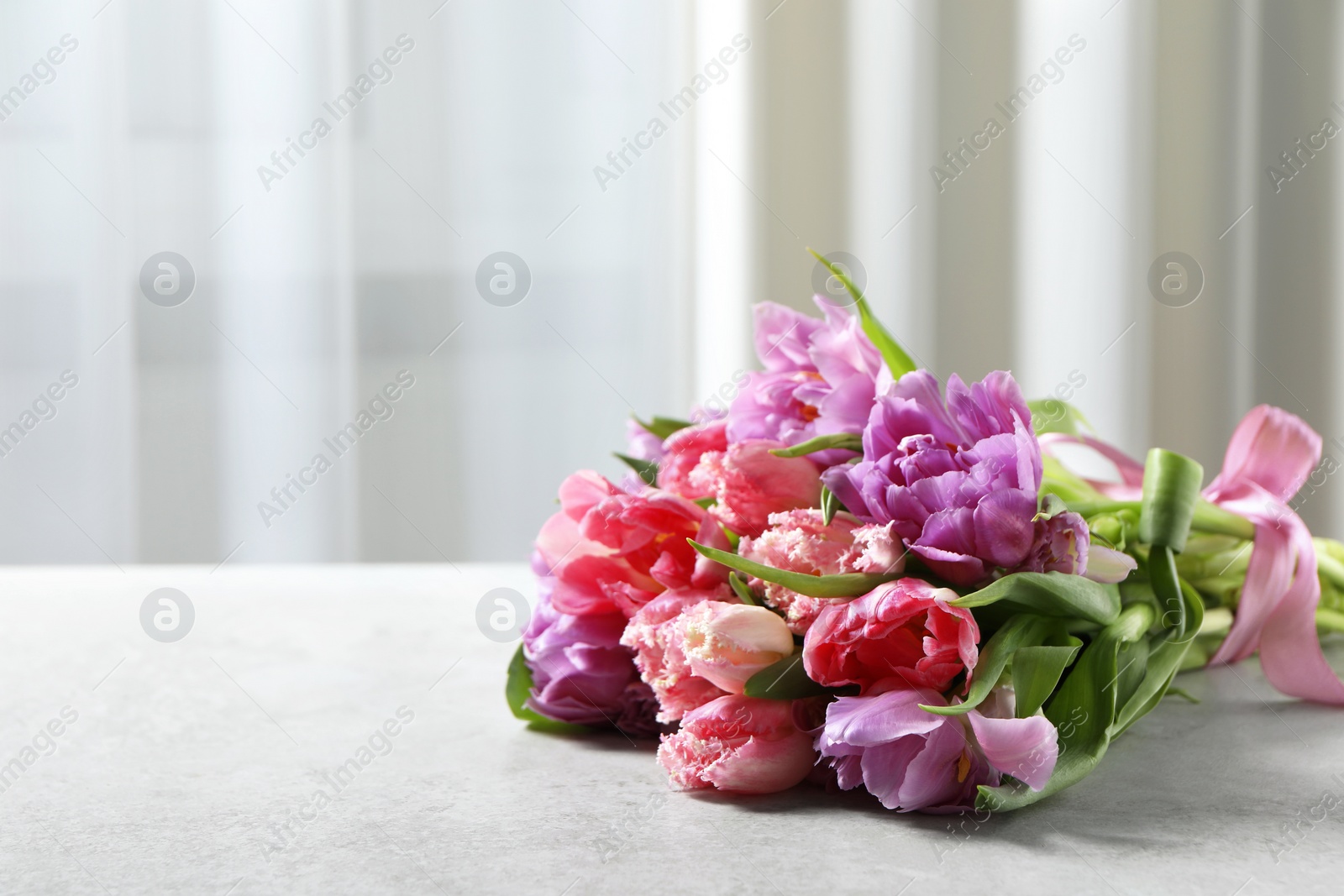 Photo of Beautiful bouquet of colorful tulip flowers on light gray table