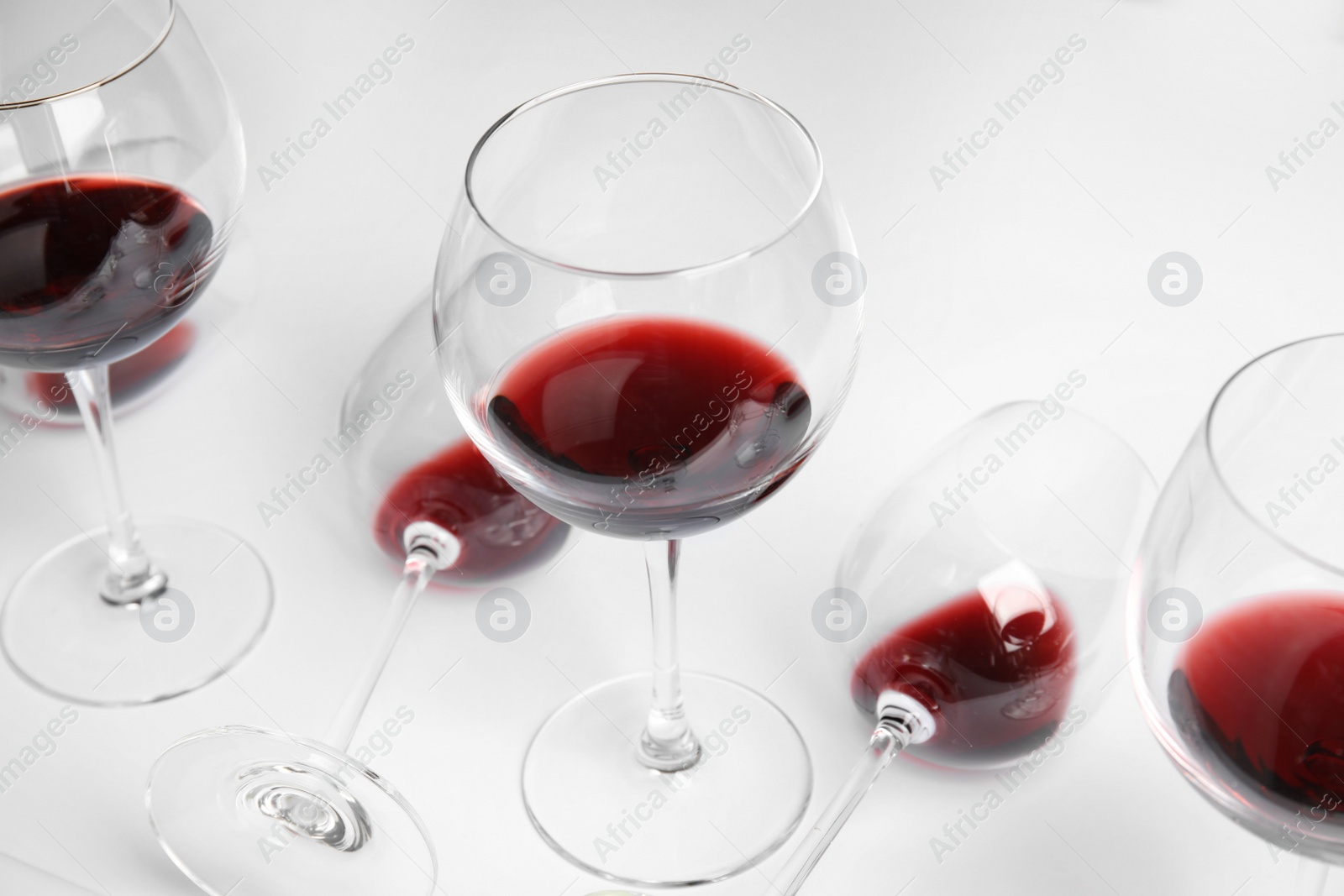 Photo of Transparent glasses with exquisite red wine on white background