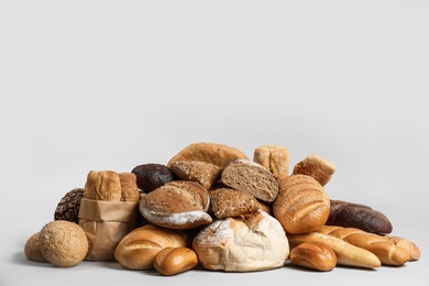 Photo of Pile of fresh tasty bread on light background