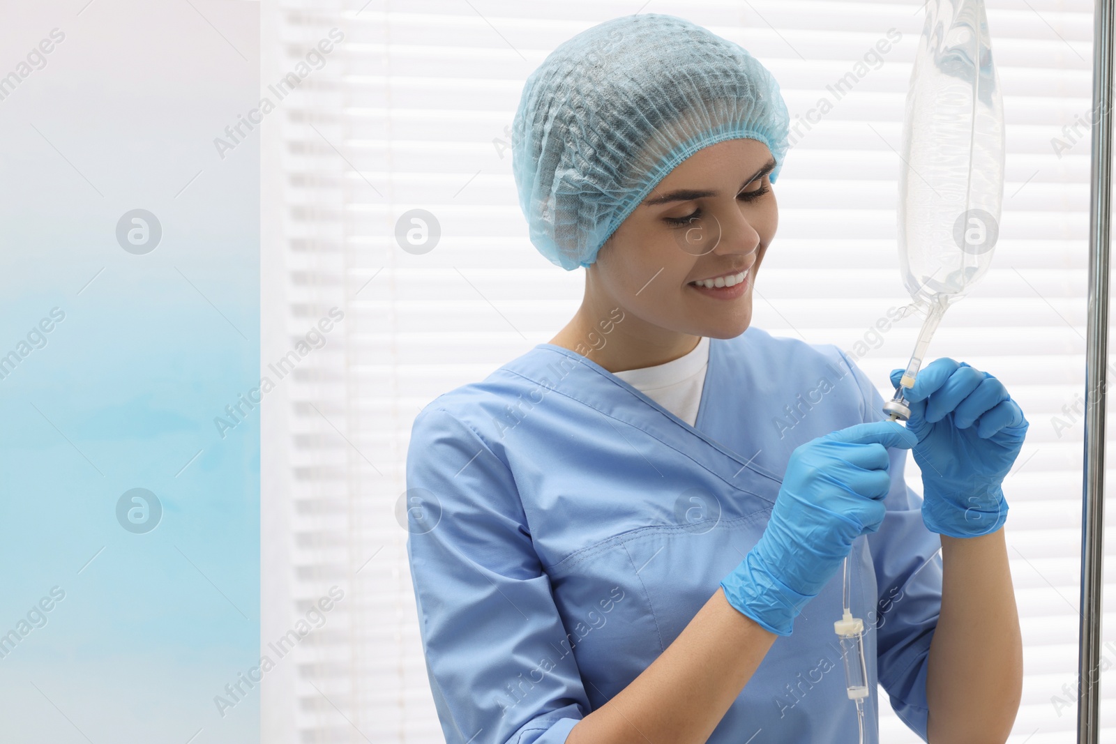 Photo of Nurse setting up IV drip in hospital, space for text