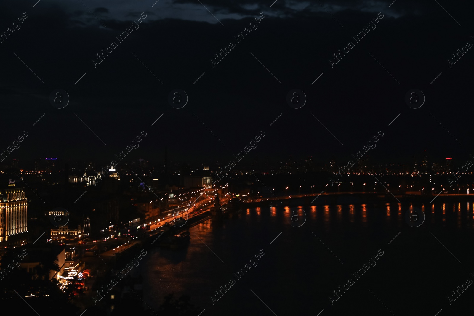 Photo of KYIV, UKRAINE - MAY 21, 2019: Beautiful view of night cityscape with illuminated buildings near river