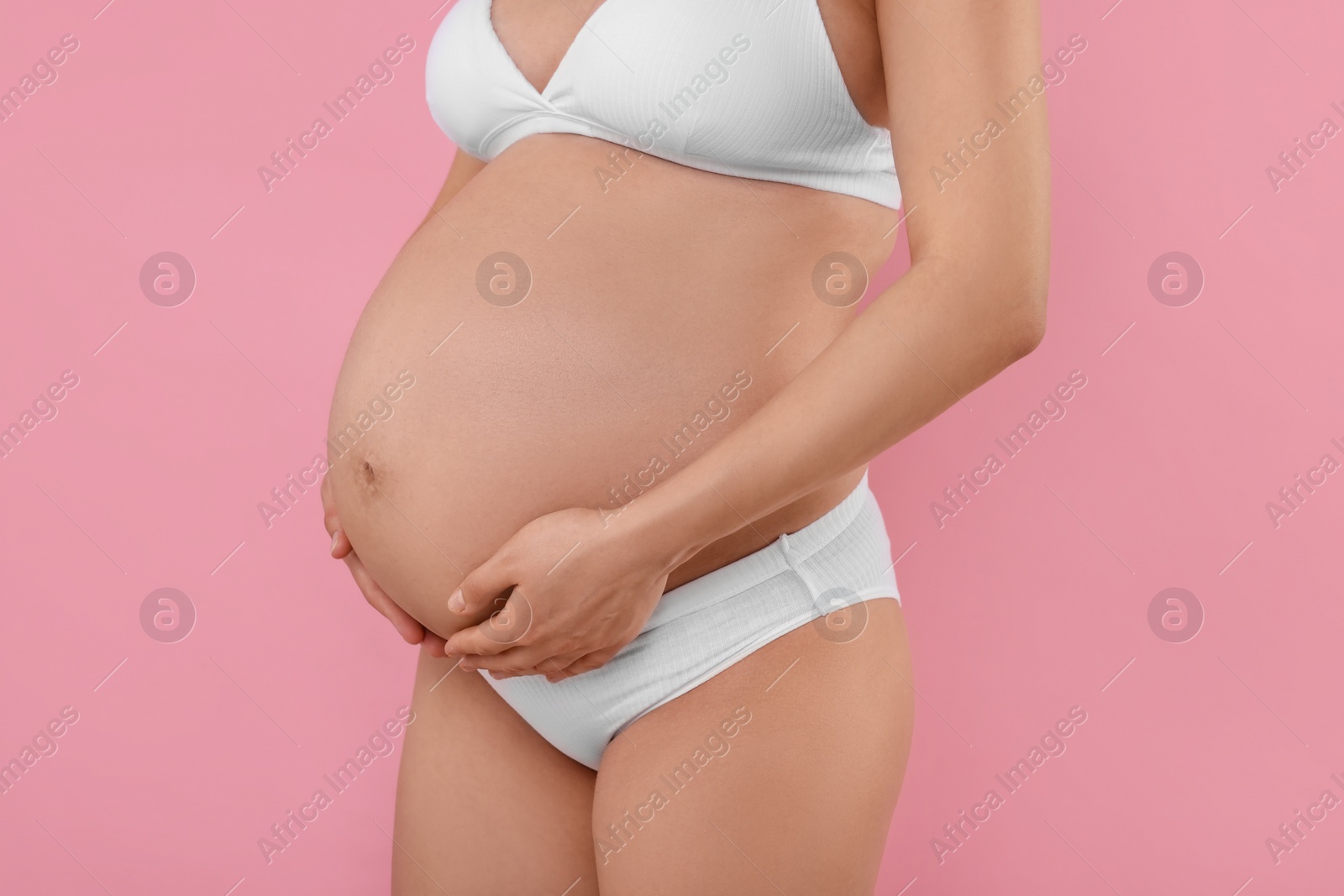 Photo of Pregnant woman in stylish comfortable underwear on pink background, closeup