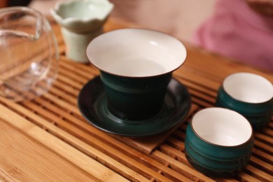 Photo of Dishware for traditional tea ceremony on wooden table