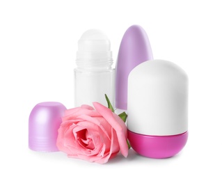 Photo of Different natural female deodorants with rose on white background. Skin care