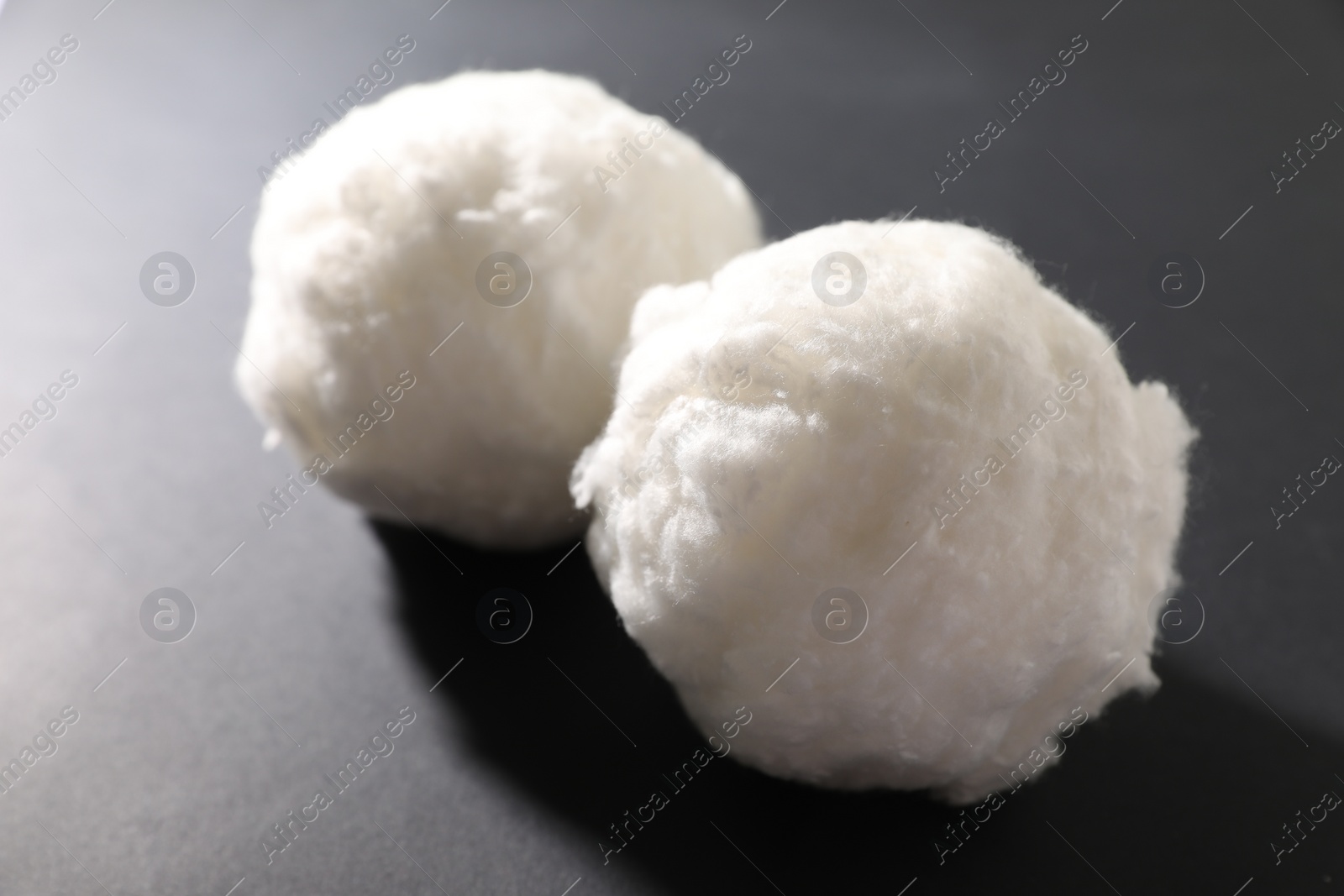 Photo of Balls of clean cotton wool on grey background, closeup