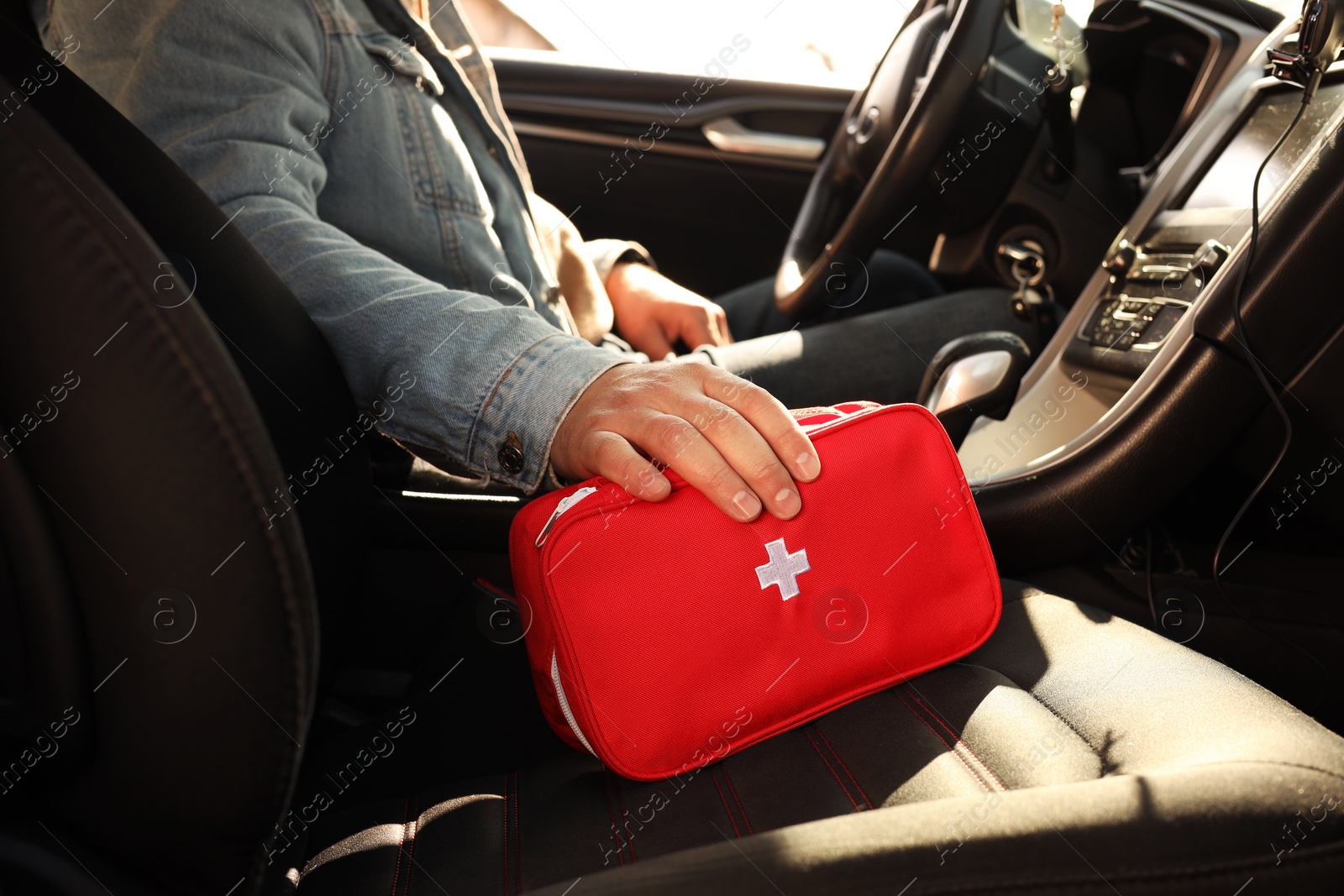 Photo of Man with first aid kit inside car, closeup