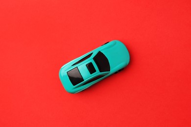 Photo of One light blue car on red background, top view