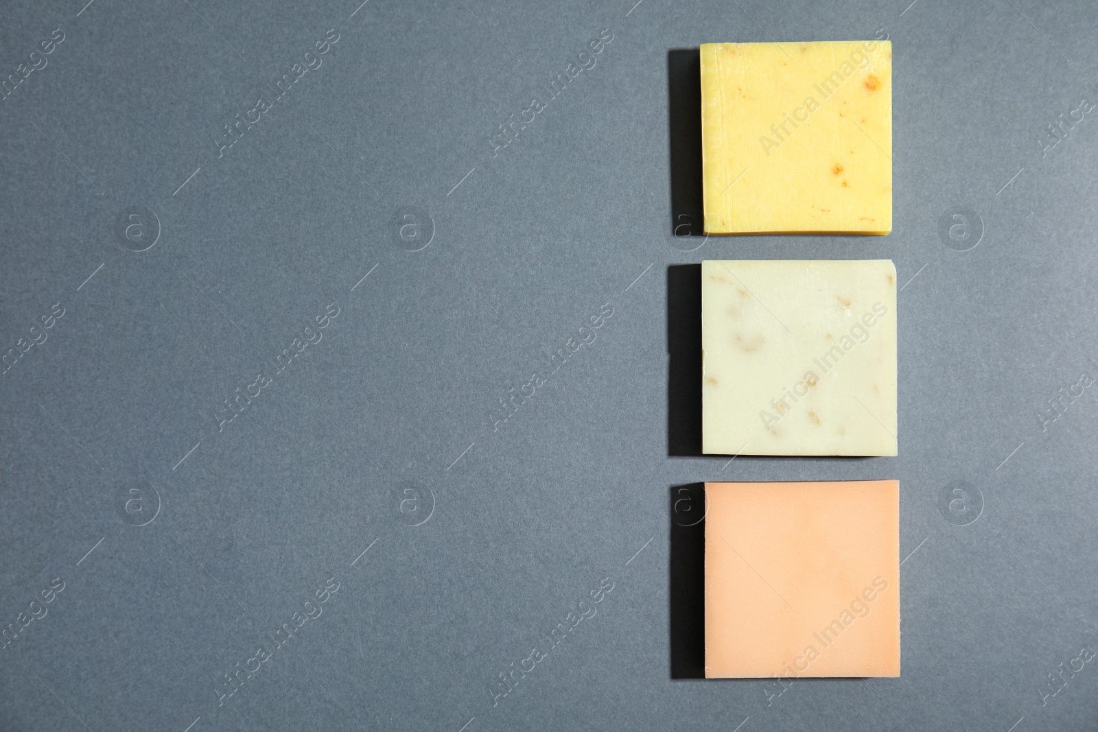 Photo of Hand made soap bars on grey background, top view. Space for text