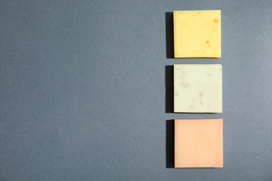 Hand made soap bars on grey background, top view. Space for text