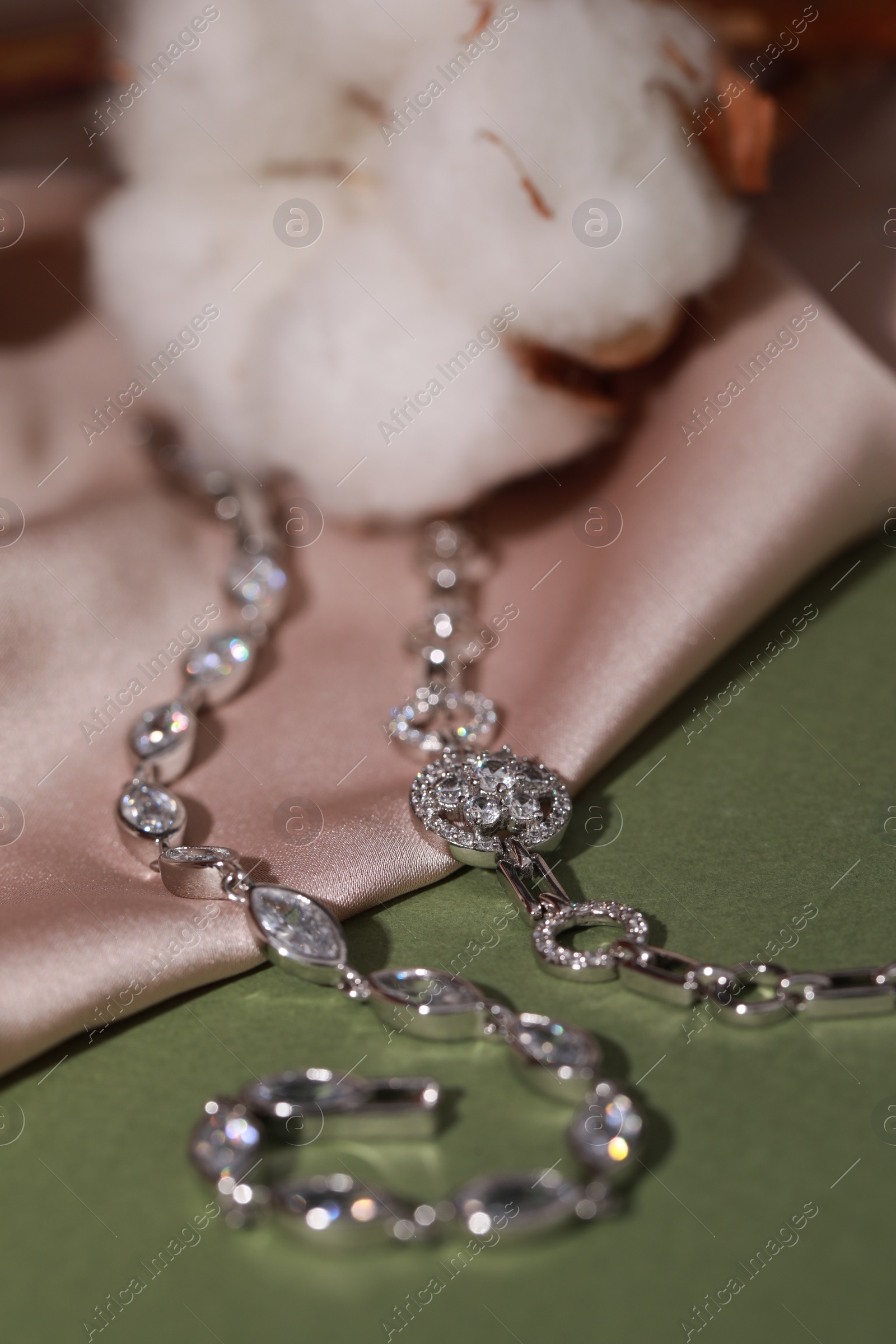 Photo of Elegant jewelry. Stylish presentation with luxury bracelets on dark green background, closeup