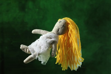 Photo of Female voodoo doll with pins and smoke on green background