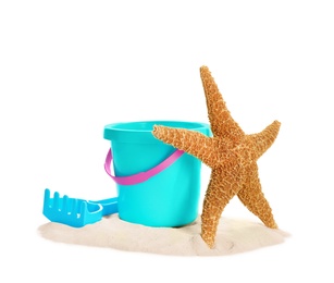 Photo of Plastic beach toys and sea star on pile of sand against white background