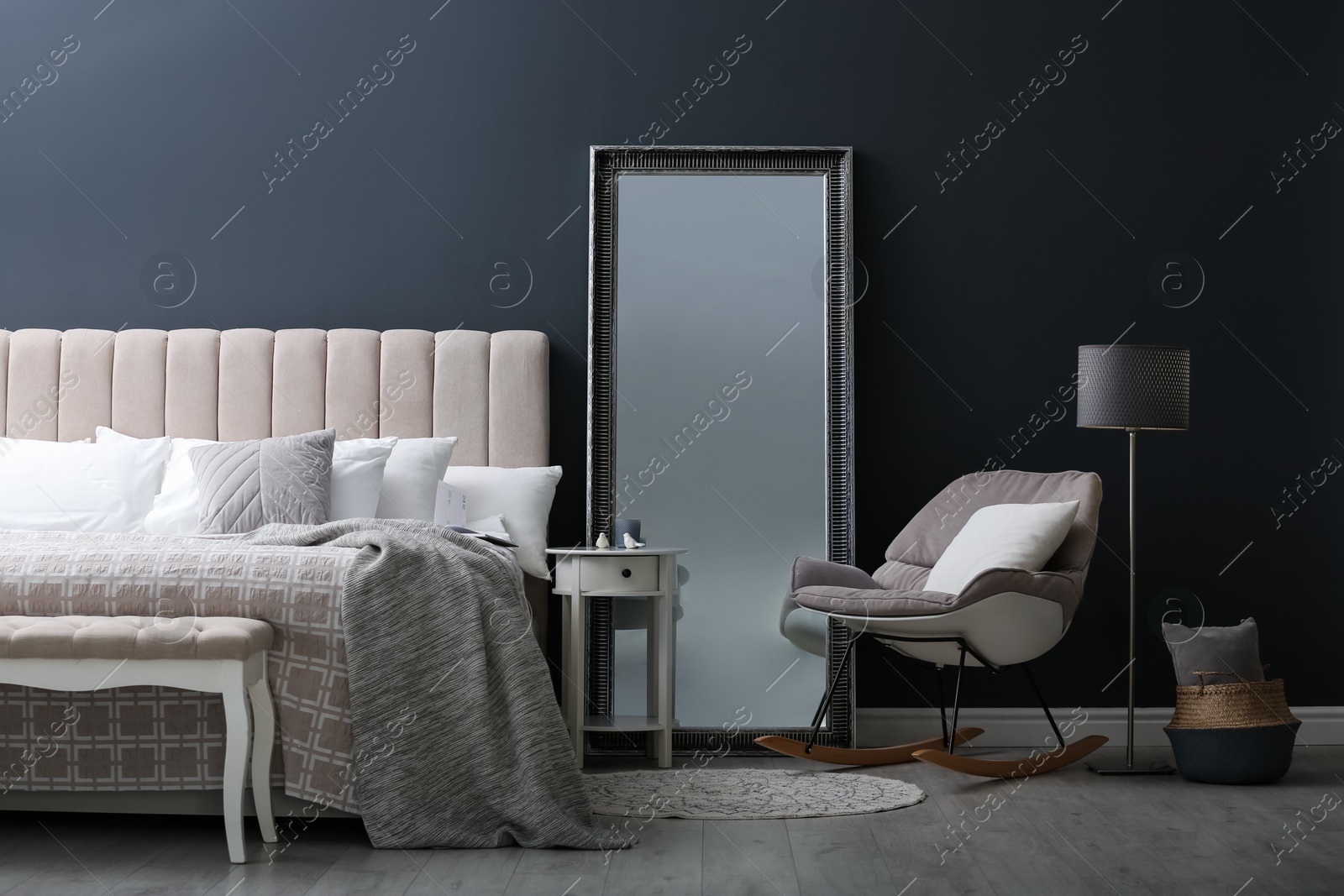 Photo of Elegant mirror near bed in stylish room interior