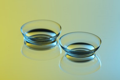 Photo of Pair of contact lenses on mirror surface, closeup