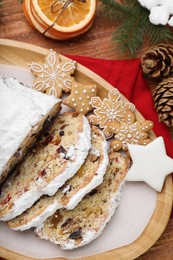 Traditional Christmas Stollen with icing sugar on wooden table, flat lay