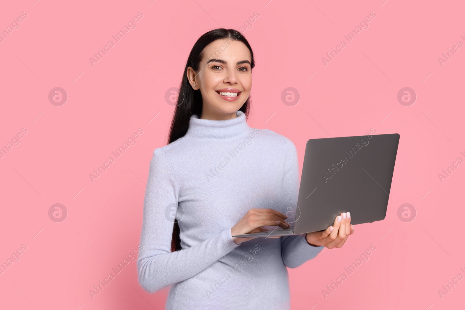 Photo of Happy woman with laptop on pink background