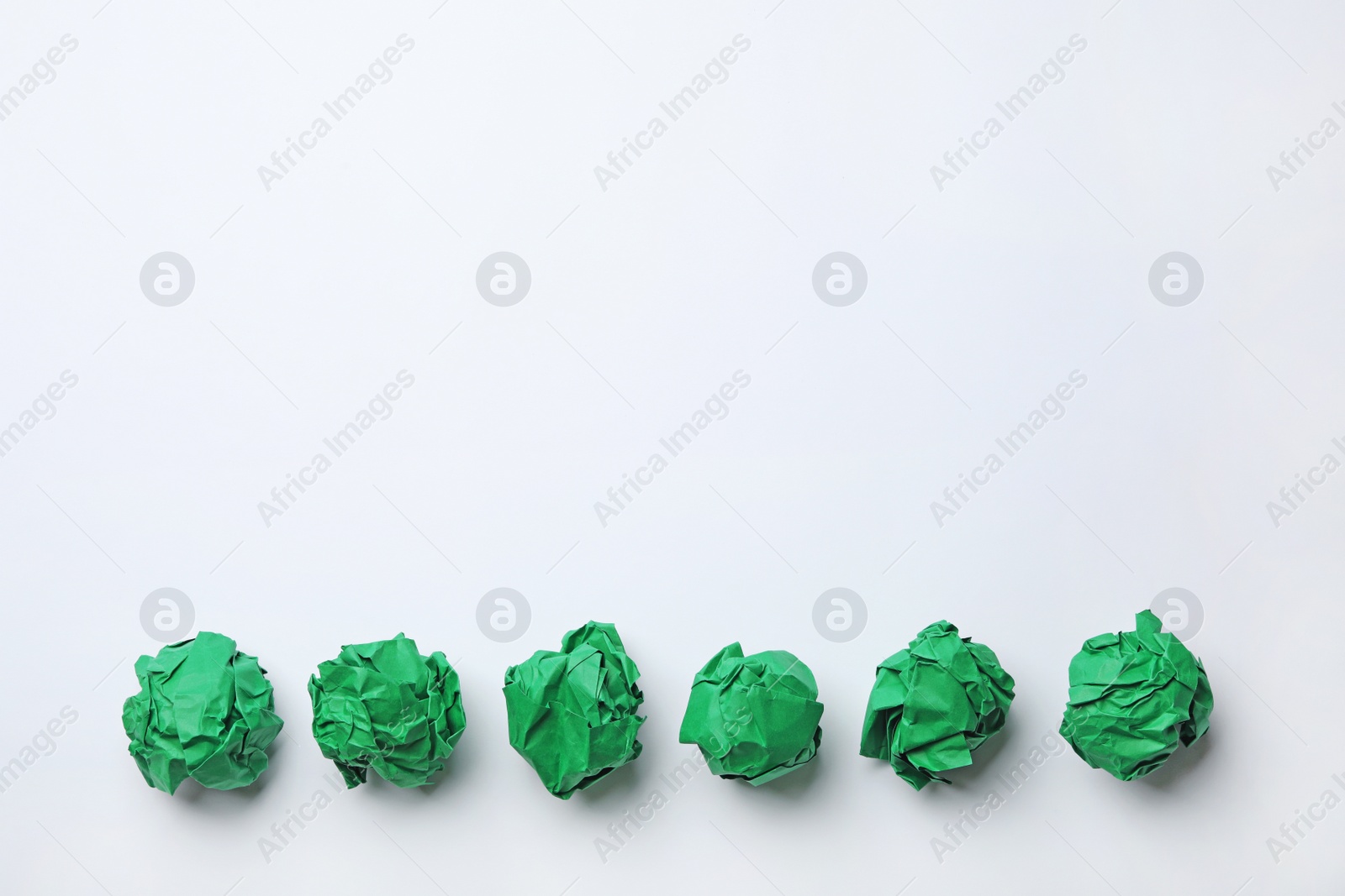Photo of Colorful crumpled sheets of paper on white background, top view