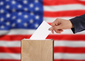 Image of Election in USA. Woman putting her vote into ballot box against national flag of United States, closeup