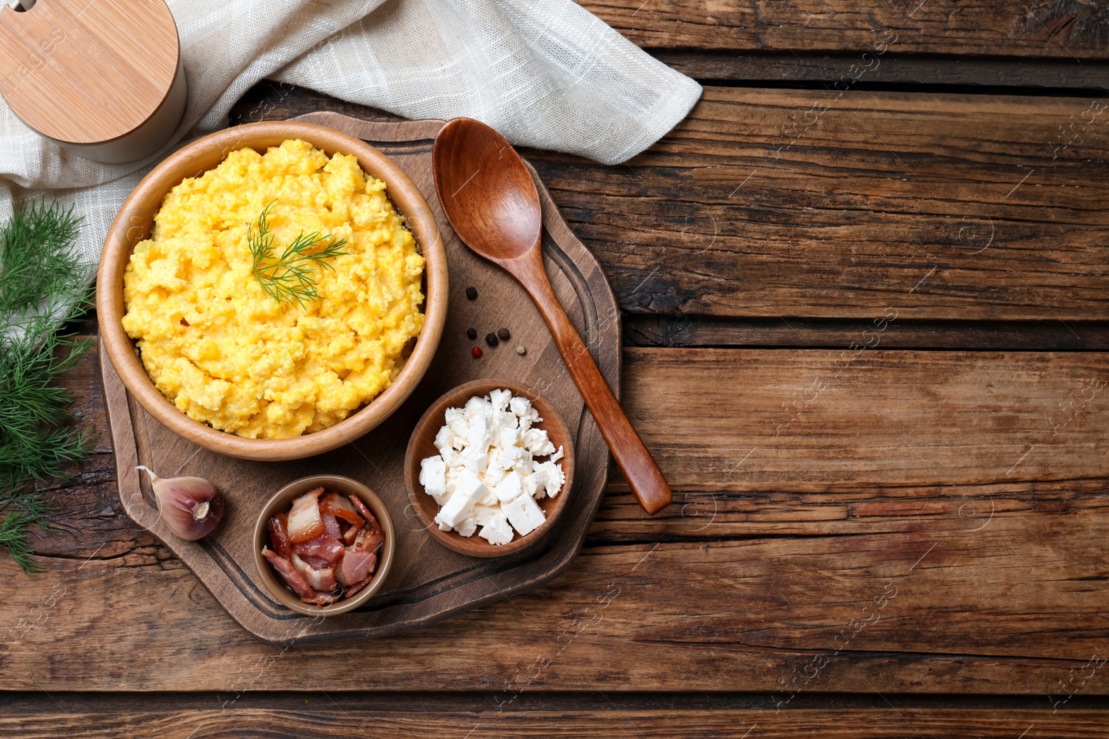 Photo of Traditional Ukrainian banosh served with brynza and pork cracklings on wooden table, flat lay. Space for text