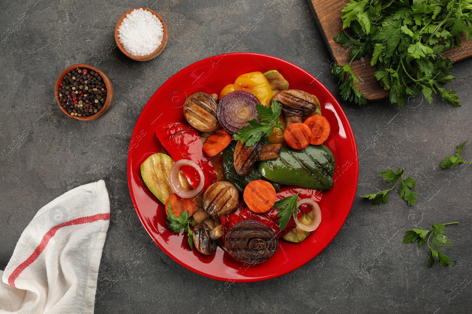 Photo of Delicious grilled vegetables served on grey table, flat lay