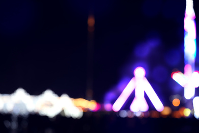 Photo of Blurred view of city street with festive lights at night. Bokeh effect