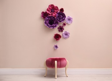 Photo of Stool near wall with floral decor in room. Interior design