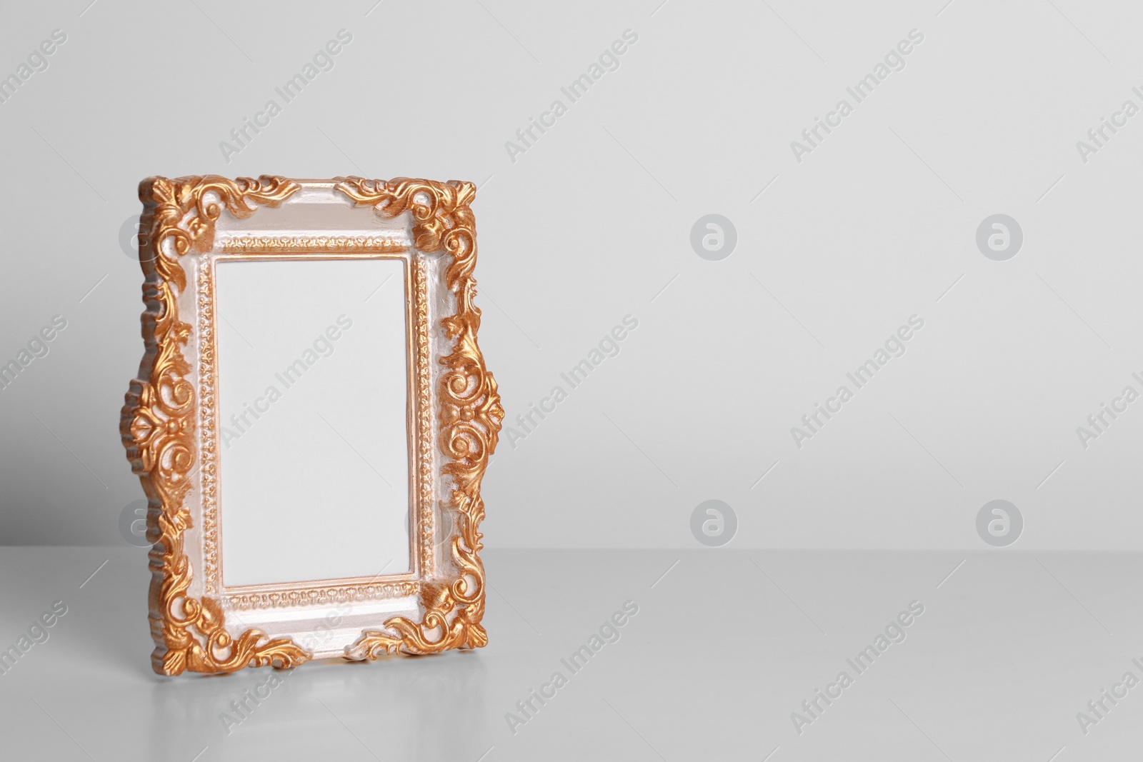 Photo of Beautiful vintage empty frame on white table, space for text