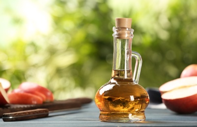 Photo of Composition with jug of apple vinegar on table. Space for text