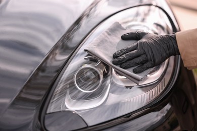 Woman wiping her modern car with rag, closeup