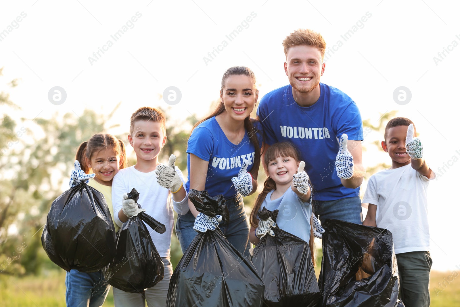 Photo of Volunteers and kids with bags of trash in park