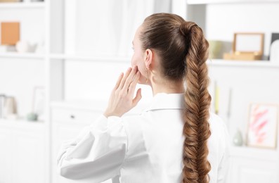 Woman with long braided hair at home