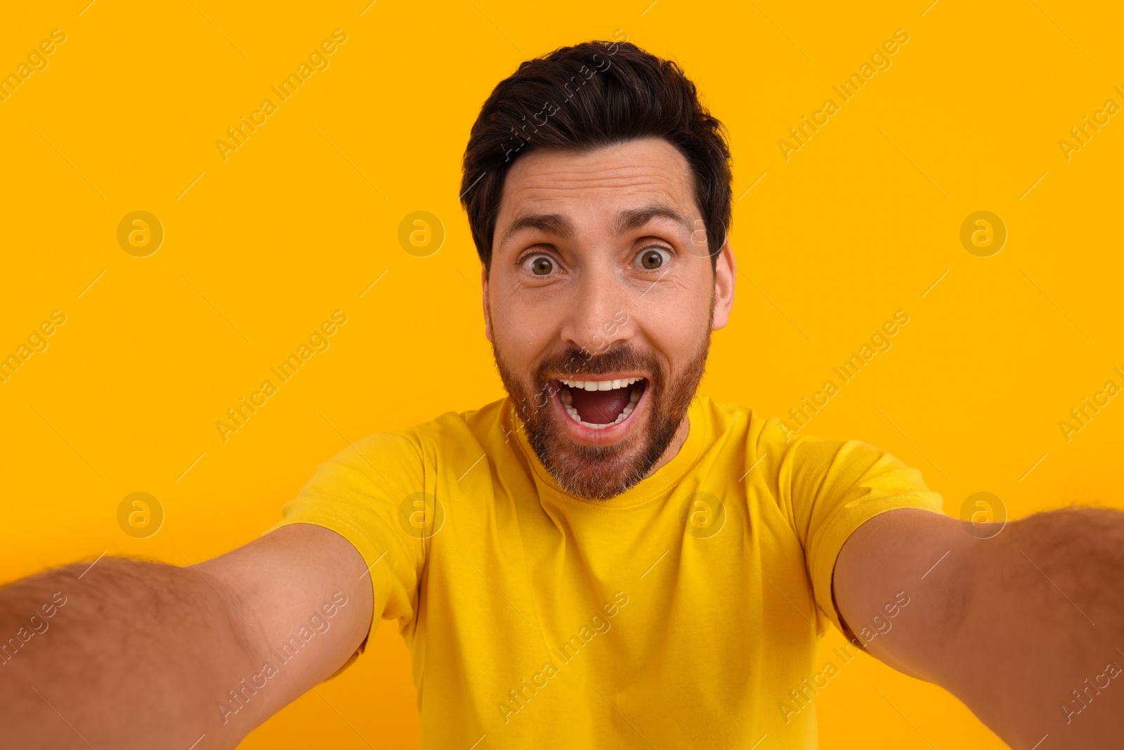 Photo of Happy man taking selfie on yellow background