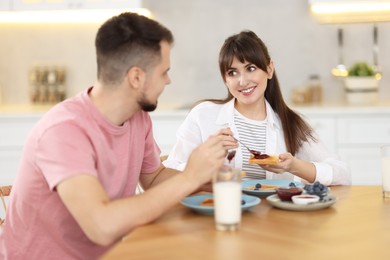 Happy couple having tasty breakfast at home, selective focus