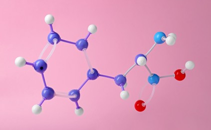 Photo of Molecule of phenylalanine on pink background. Chemical model