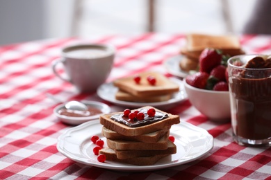 Photo of Toasted bread with chocolate spread and cranberries on table in kitchen