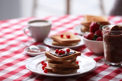 Toasted bread with chocolate spread and cranberries on table in kitchen