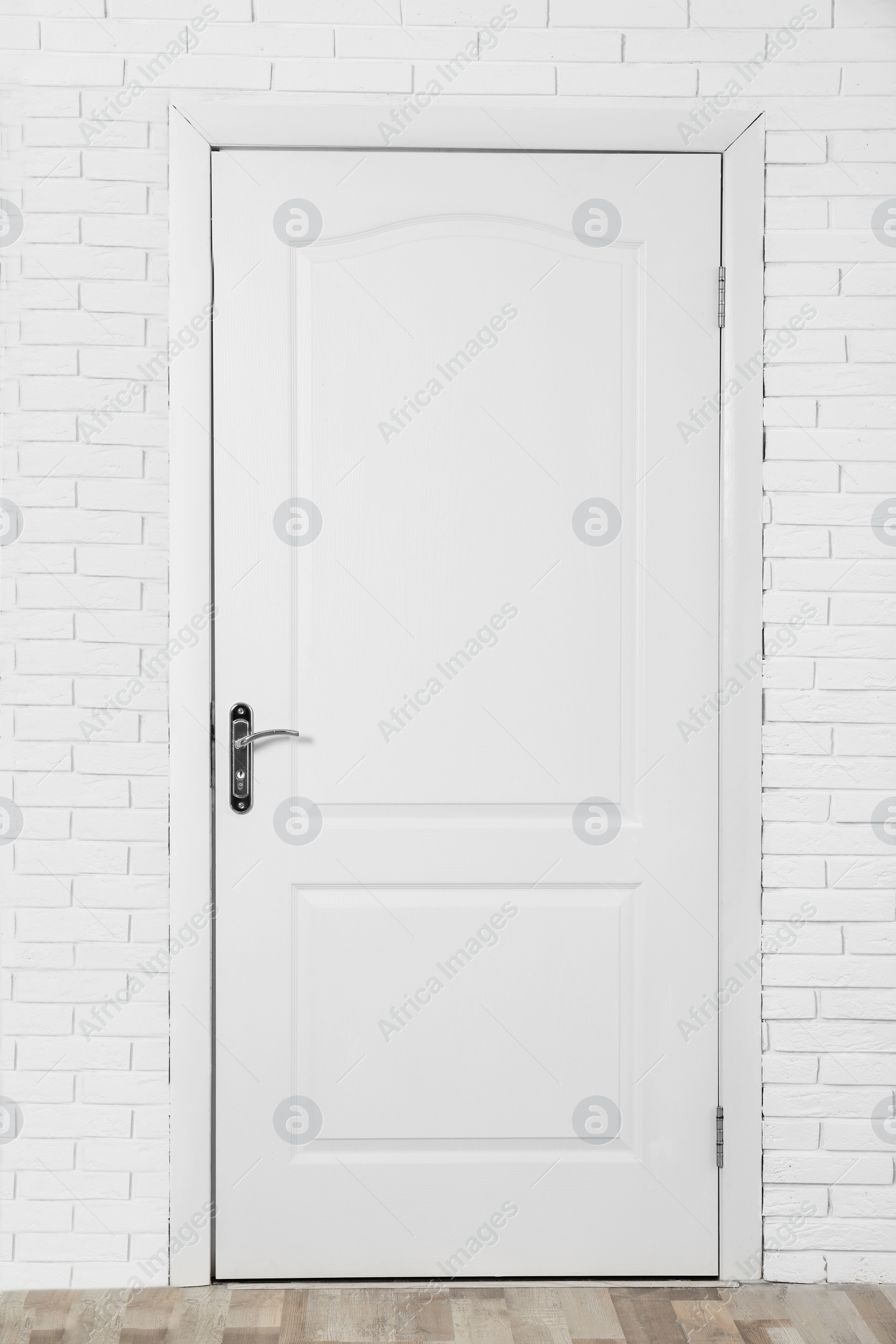 Photo of Closed white wooden door in brick wall