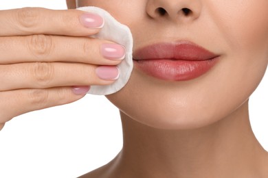 Beautiful woman removing makeup with cotton pad on white background, closeup