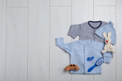 Flat lay composition with clothes and space for text on wooden background. Baby accessories