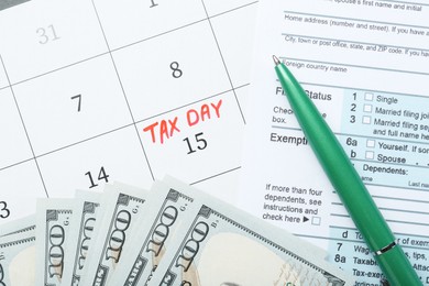 Photo of Tax day. Document, dollar banknotes and pen on calendar with date reminder, flat lay