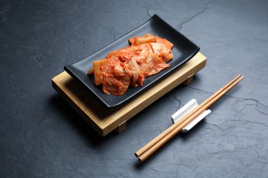 Photo of Delicious kimchi with Chinese cabbage served on grey table